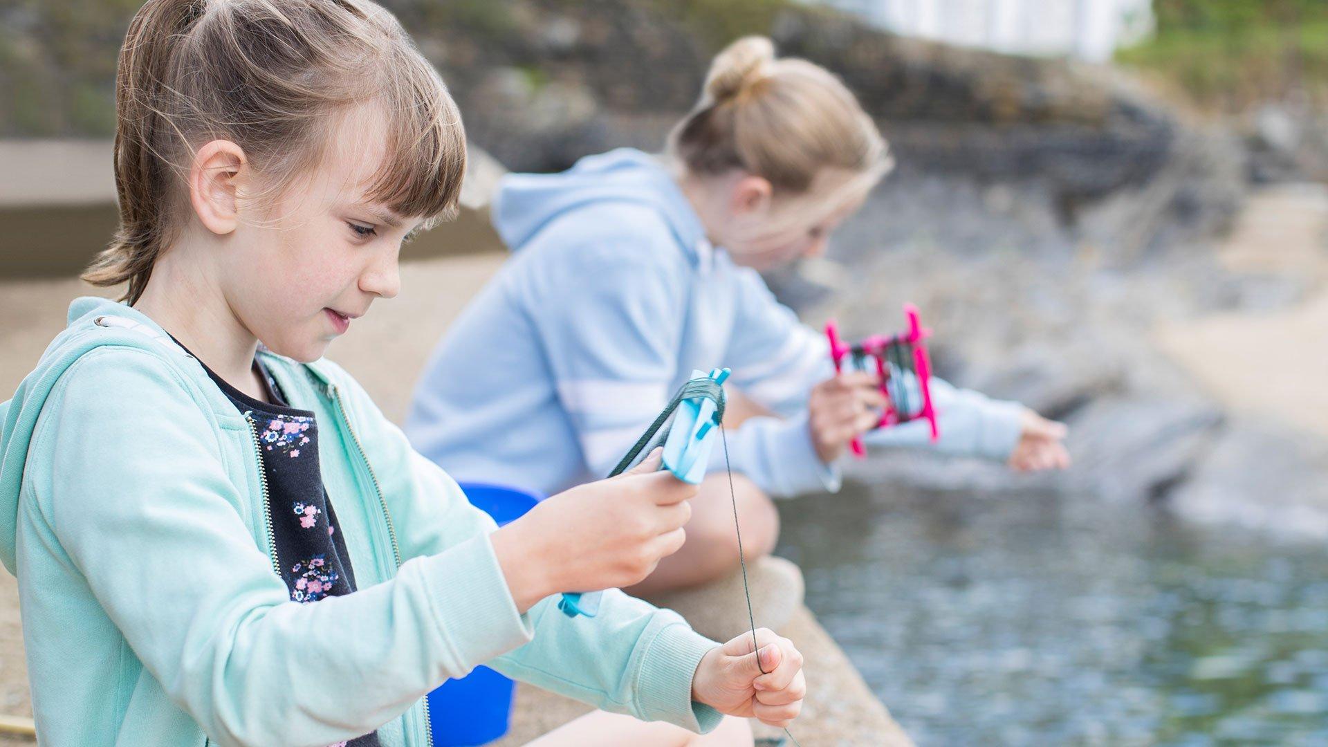 Kids crabbing with crab line off a pier.