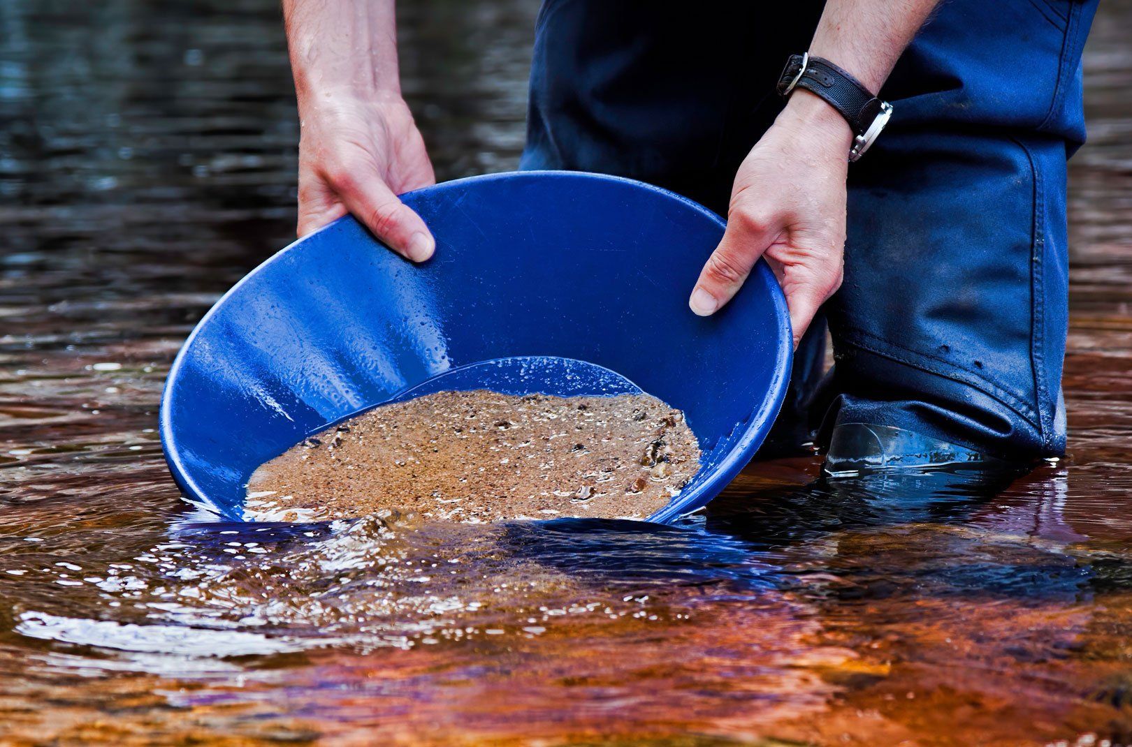 Man panning for gold in river