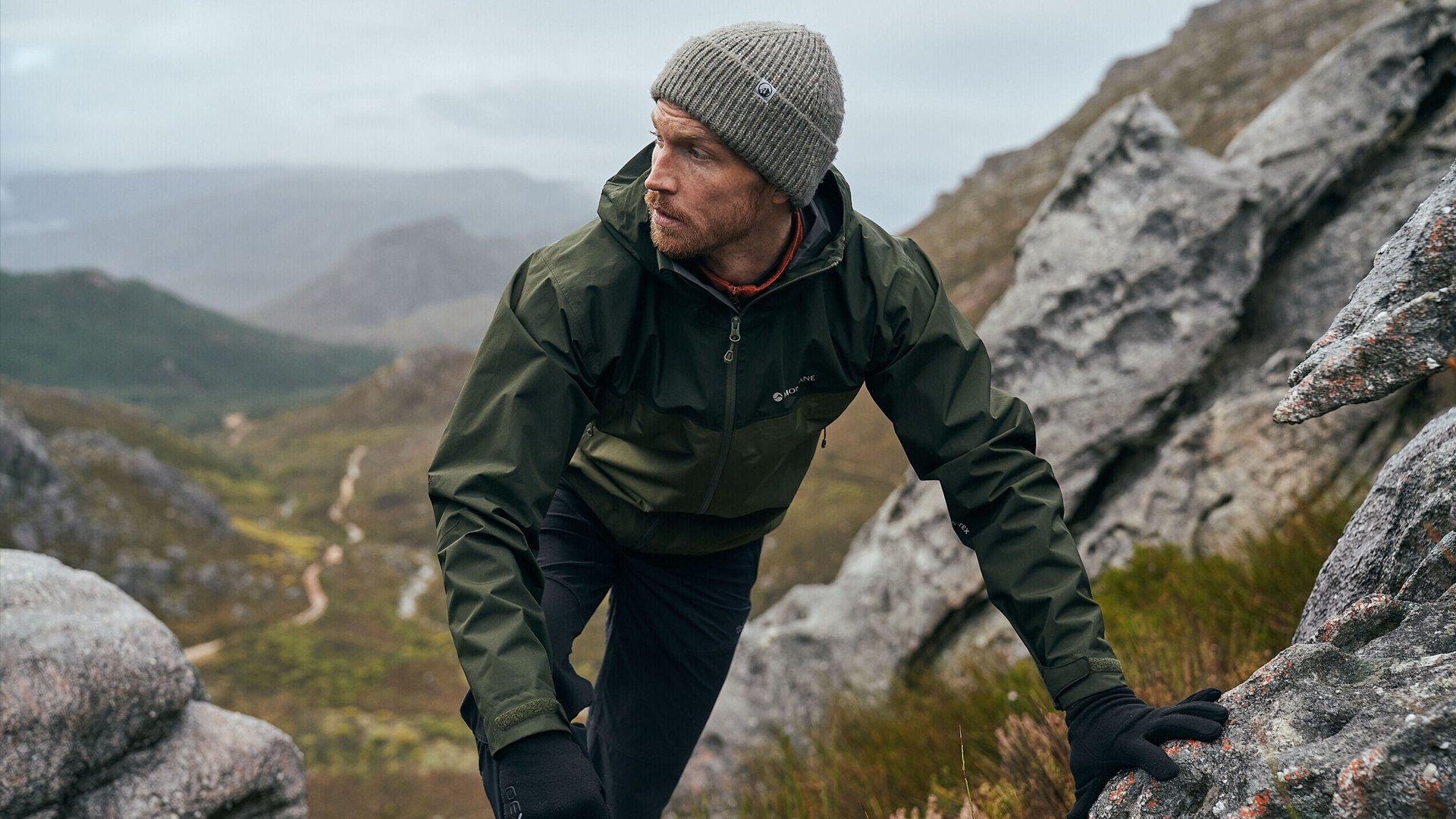 A hiker scrambling towards the summit of a mountain