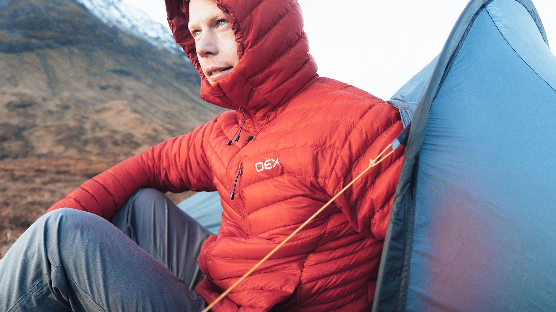 A wild camper sat in the porhc of their backpacking tent, enjoying the view of the mountains