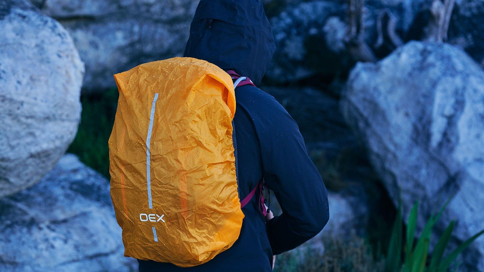 A backpacker using the rain cover on their rucksack during a rainy hike