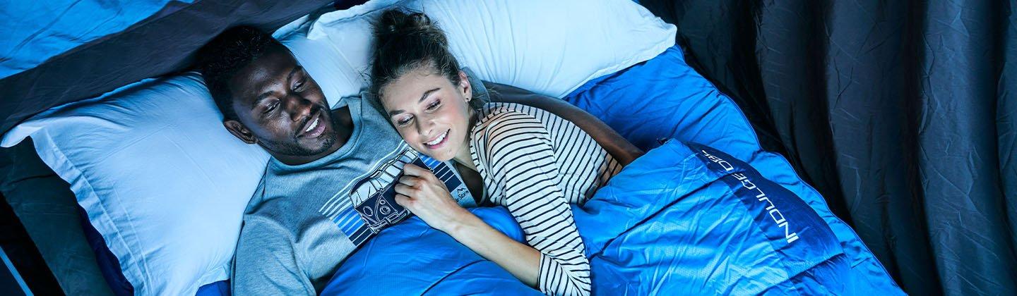 Couple cuddling up in a double sleeping bag