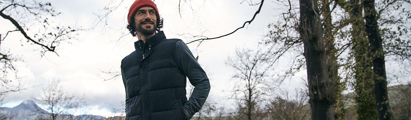 Person walking through a forest wearing a bodywarmer
