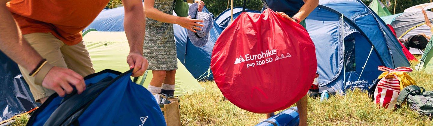 Group of people at a festival erecting their pop-up tents
