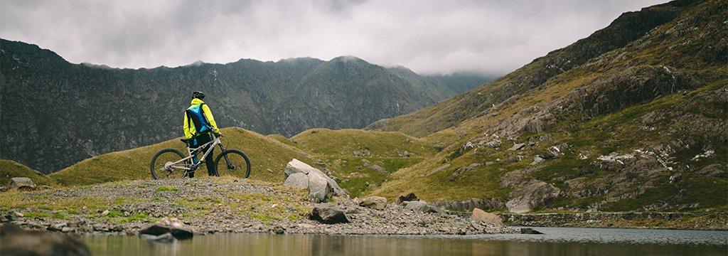 Person looking towards distant mountains standing next to a mountain bike