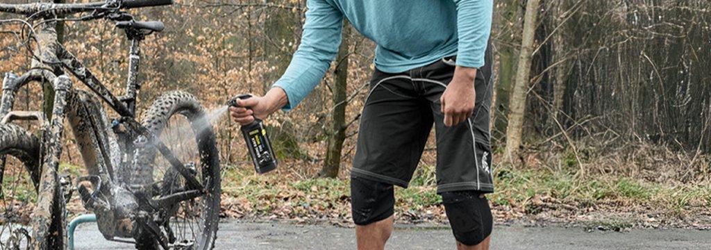 A person cleaning their bike with a dedicated cleaning spray