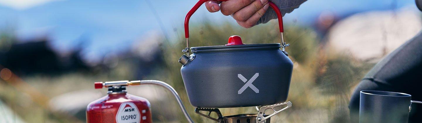 A person boiling water on a camping stove
