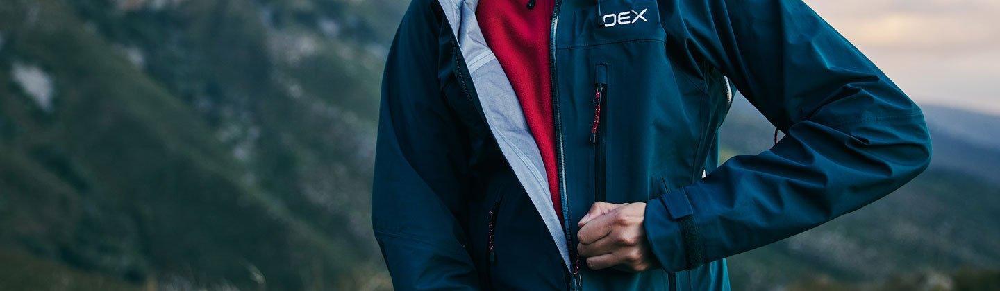 A person zipping up their waterproof jacket