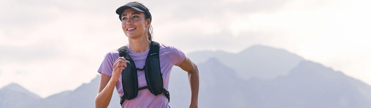 A person running in the hills wearing a hydration vest