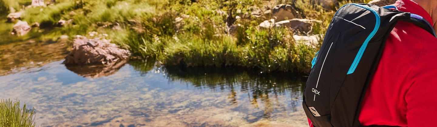 A person running in the mountains wearing a running pack