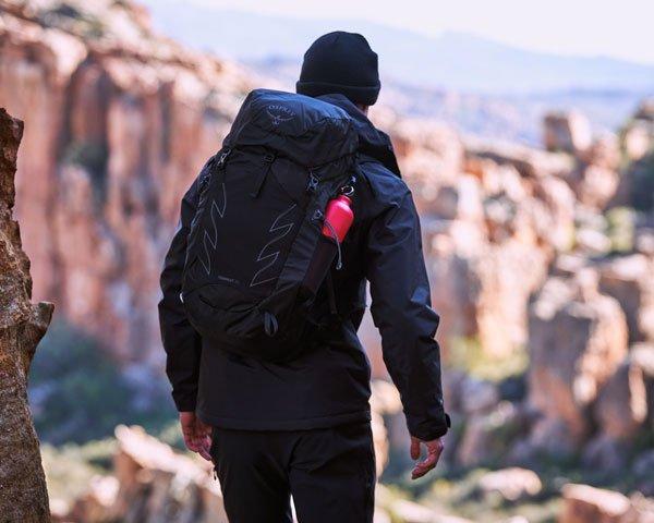 A person wearing a backpack walking in the mountains