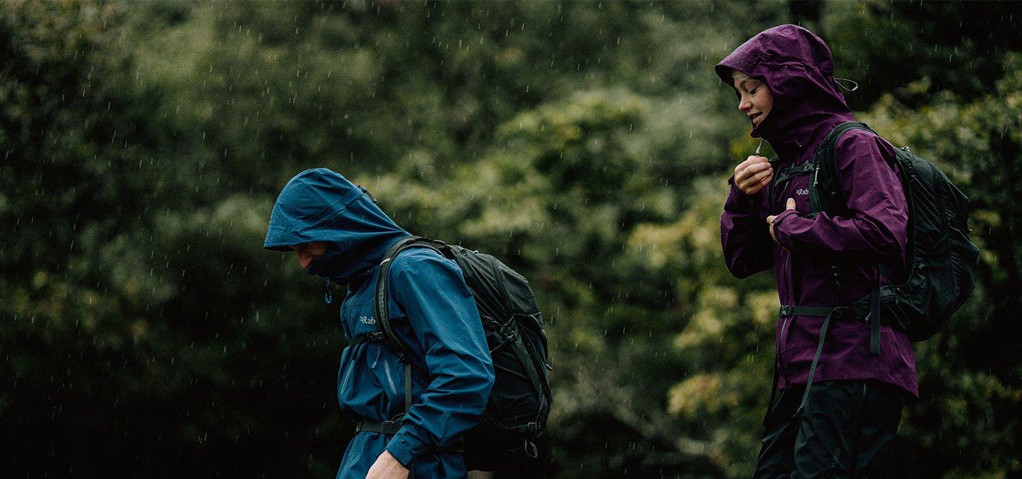 Two people in the rain wearing Rab Waterproof jackets