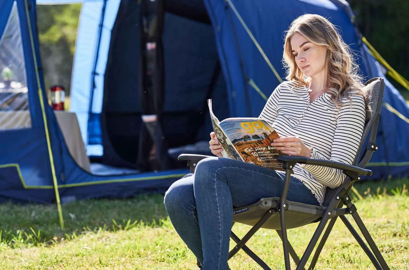 Person reading whilst sat outside camping