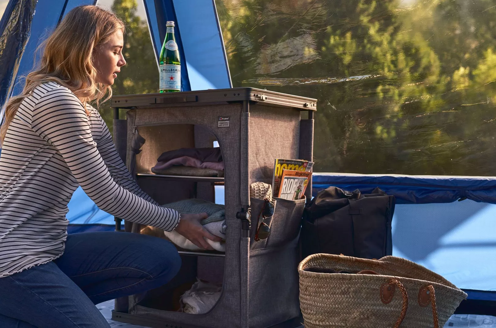 Person storing items away into camping cupboard
