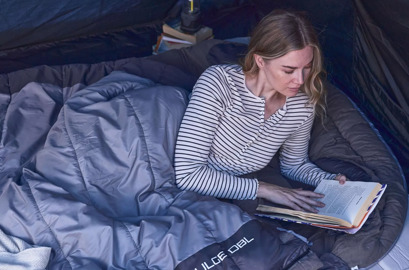 Person reading whilst in double sleeping bag