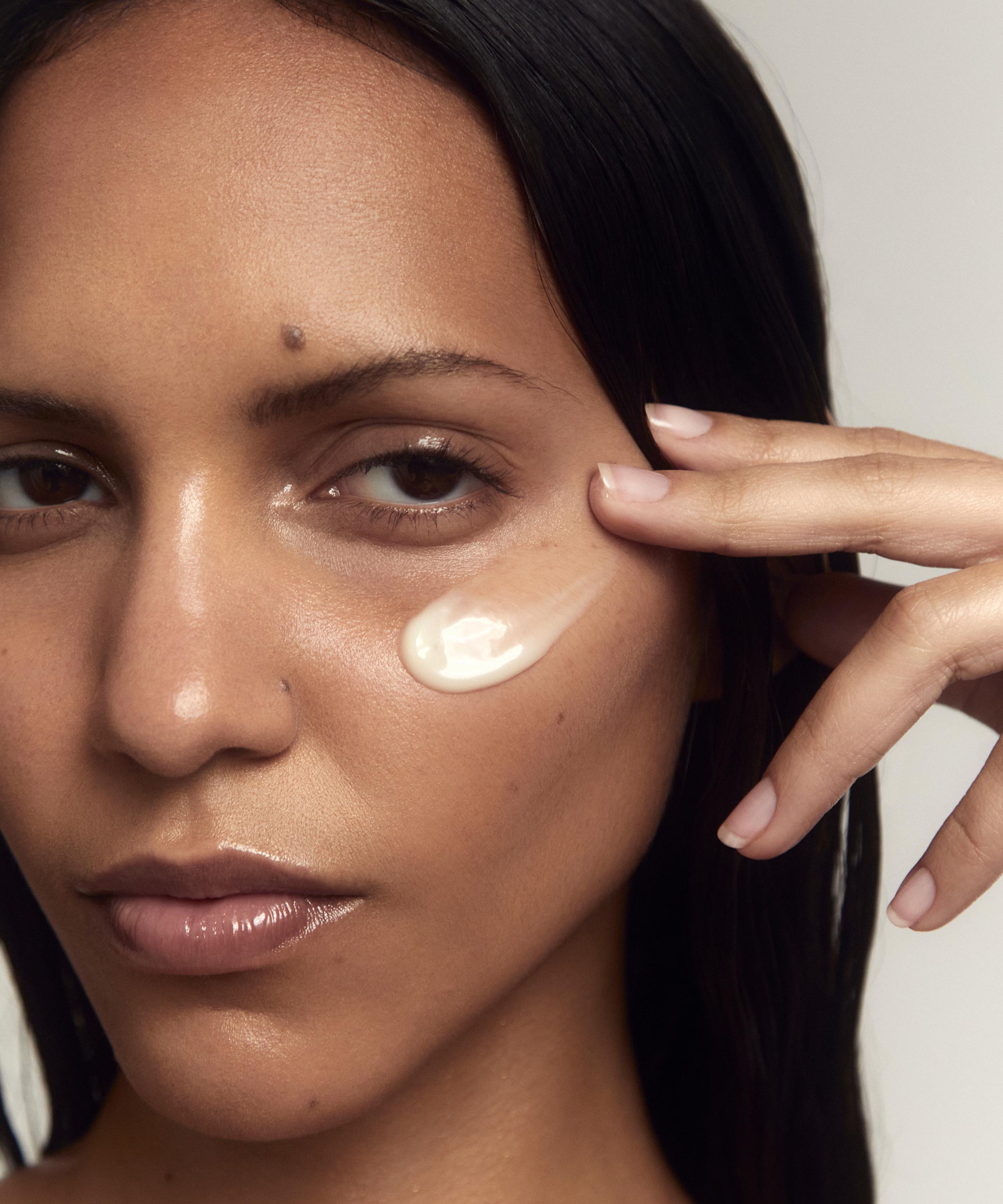 Model applying eye cream