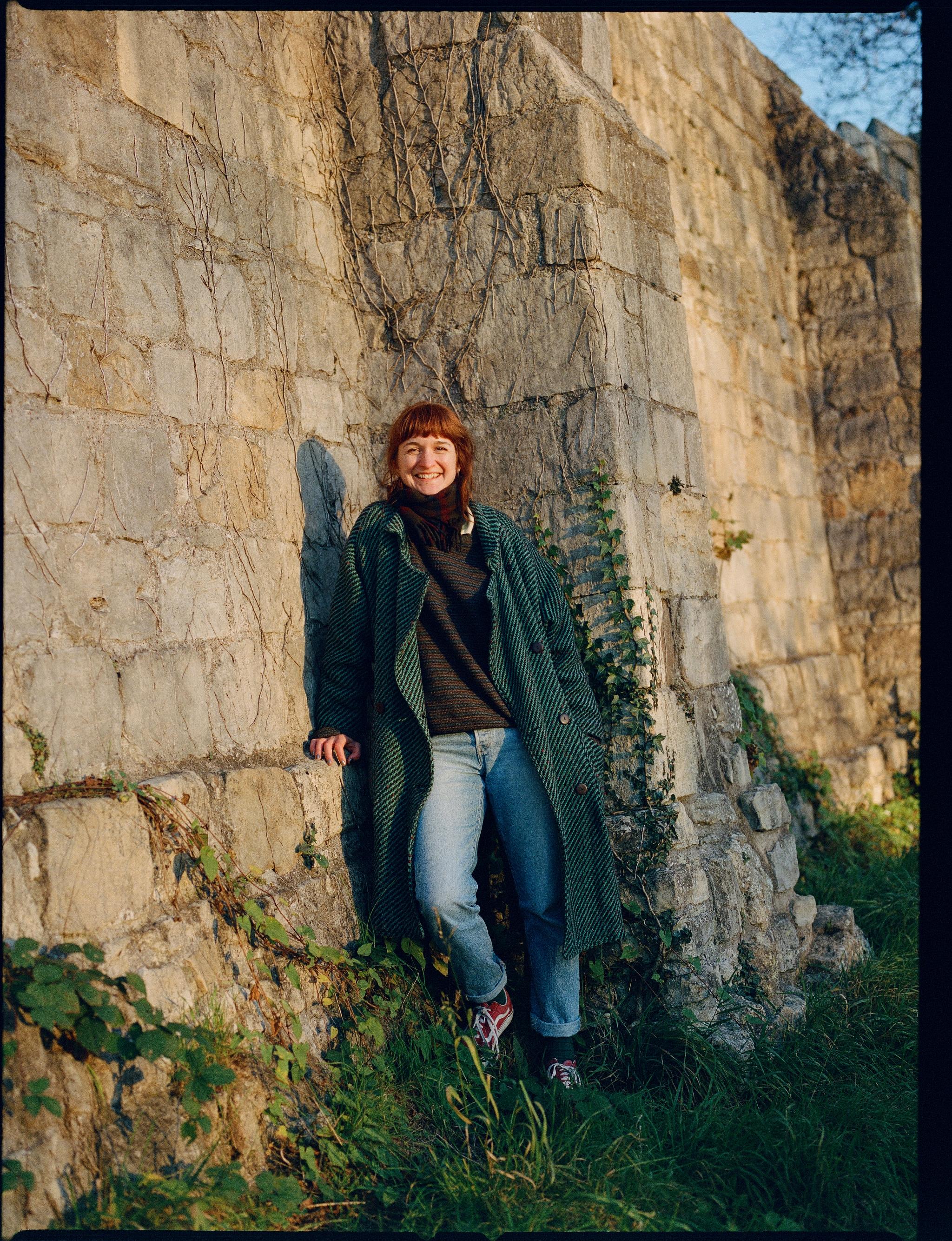 Tessa Layzelle stands in front of a stone wall