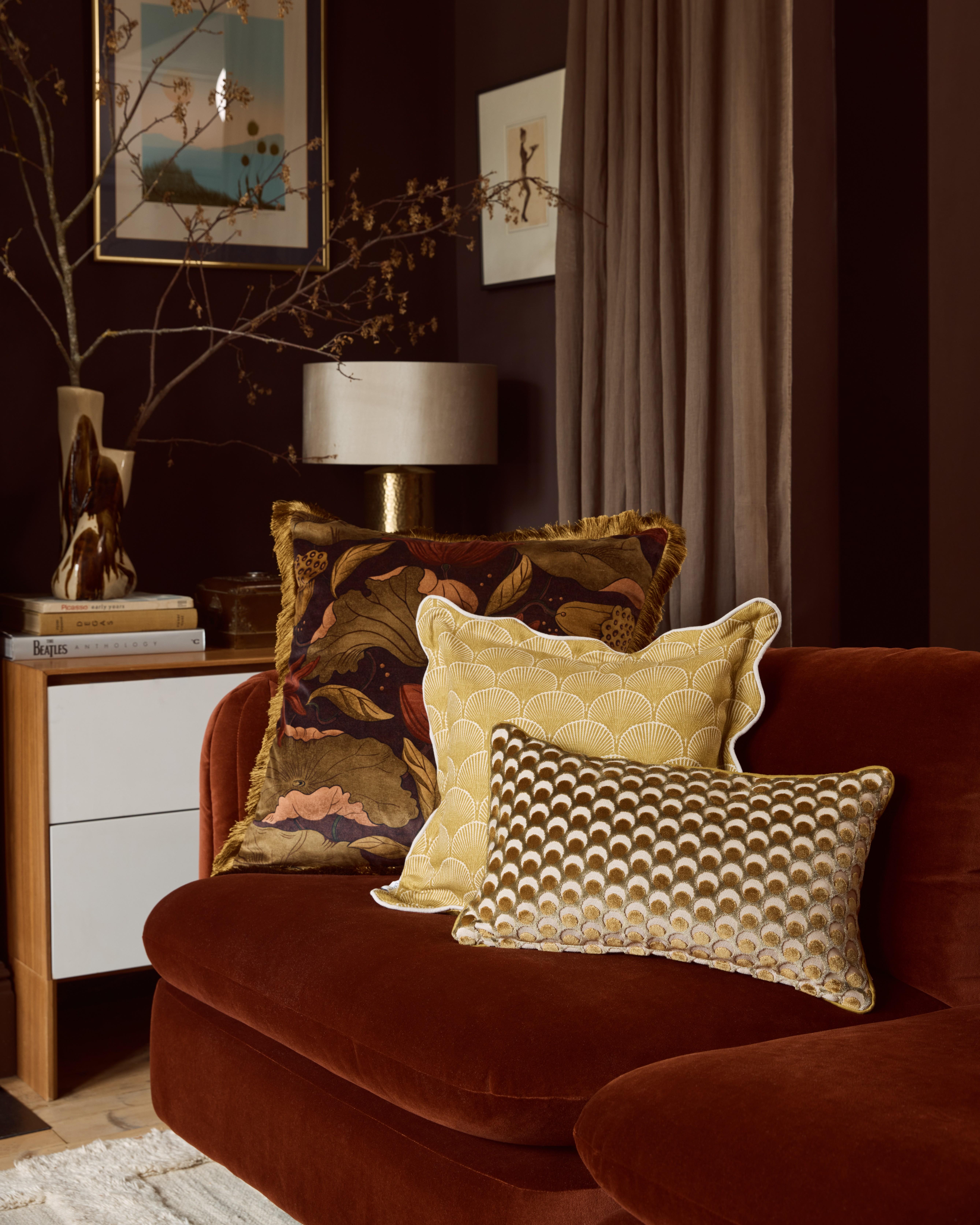 Burnt orange sofa with yellow and gold cushions