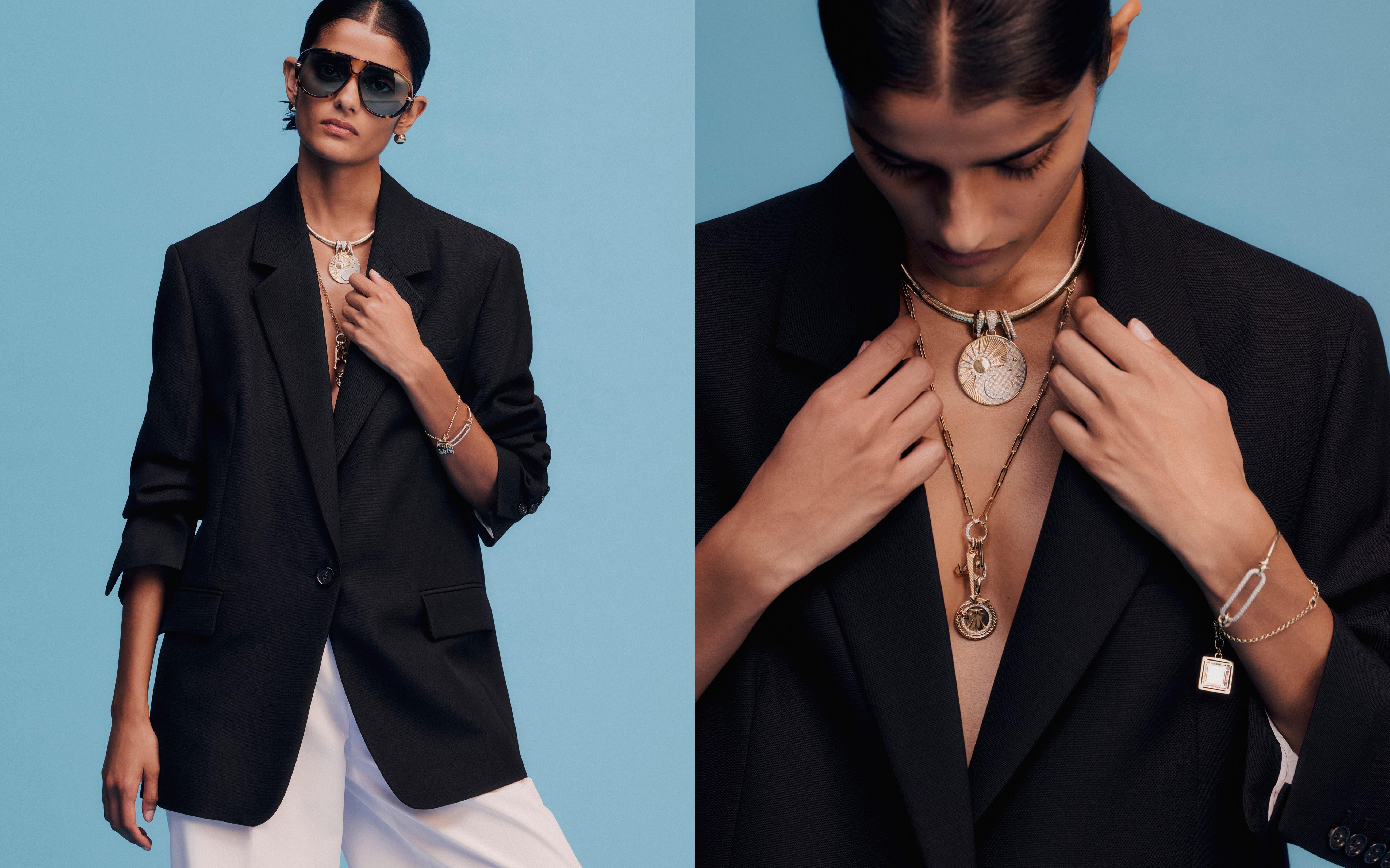 Model wearing a black blazer, white trousers and layered gold jewellery