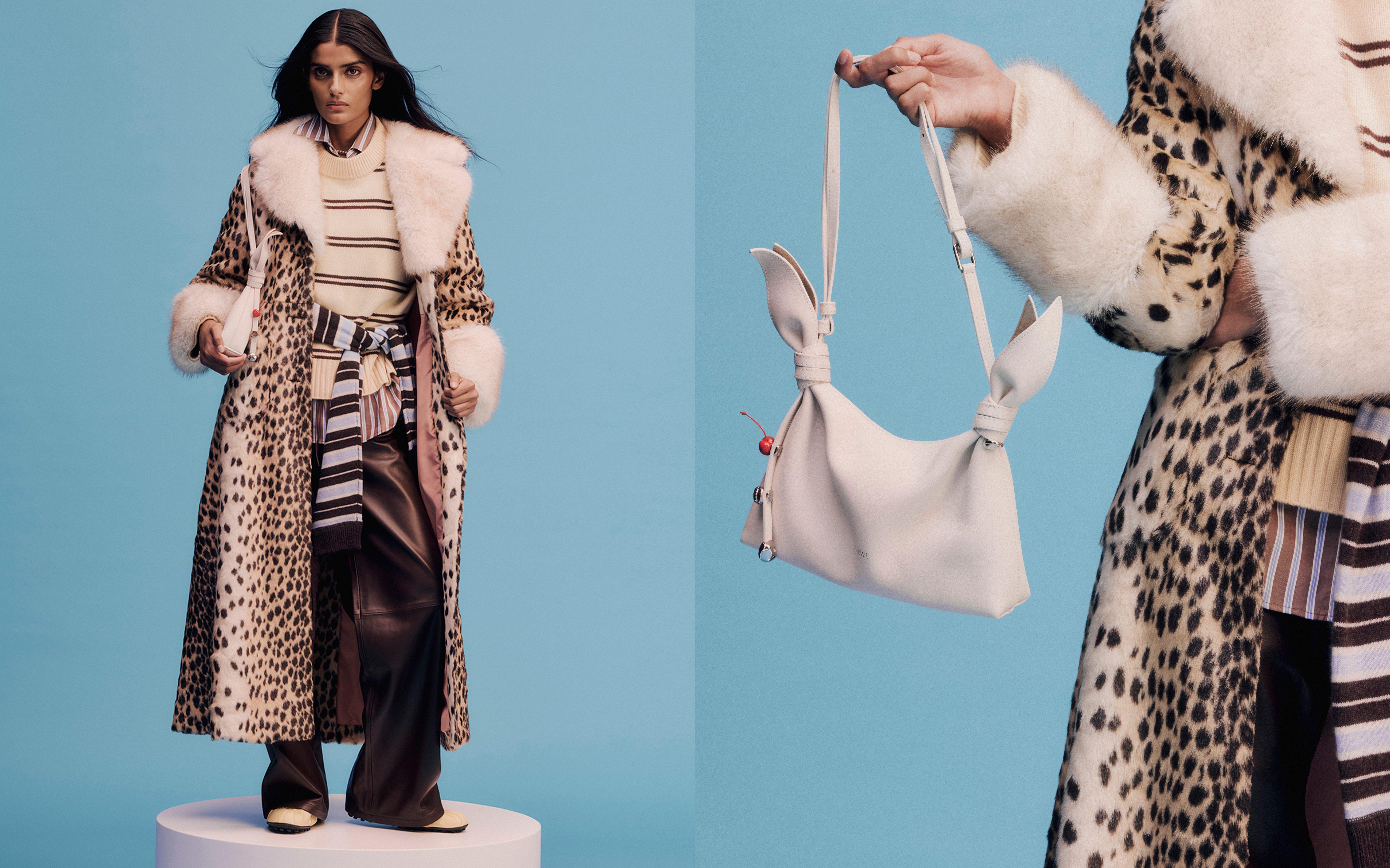 Model holding a white leather hangbag, wearing a leopard-print coat, striped shirt, striped jumper, brown leather trousers, suede mules and a striped jumper tied around their waist