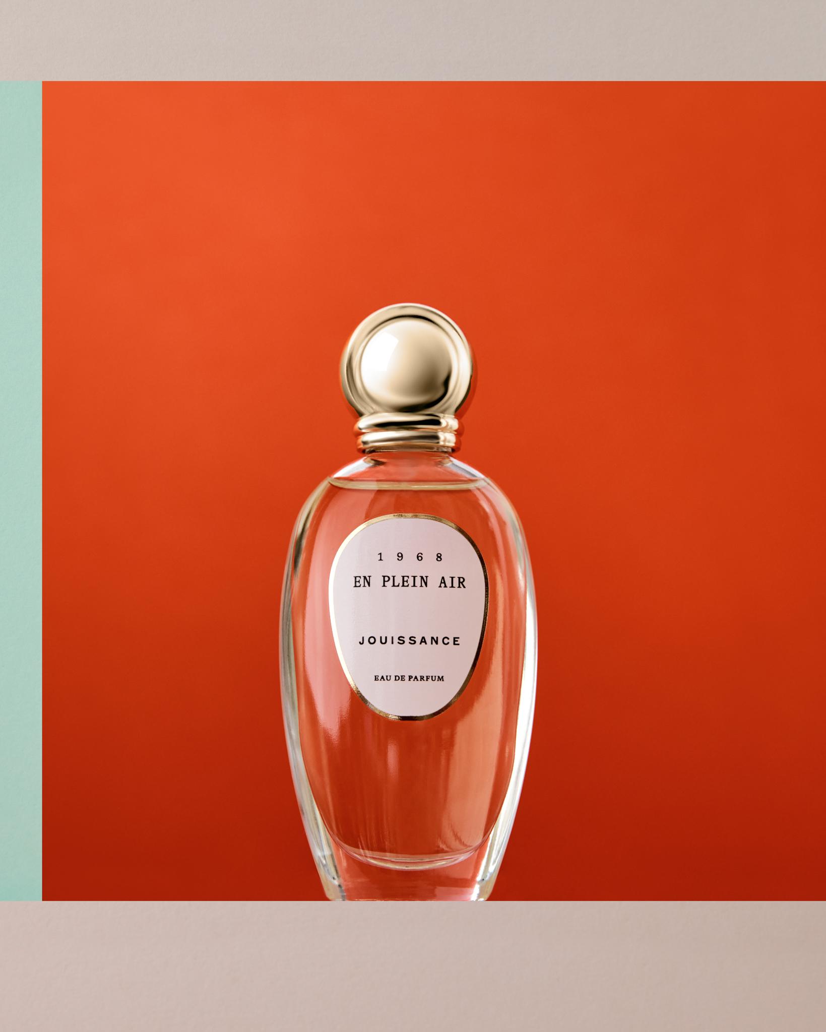 Jouissance En Plein Air Eau de Parfum in a oval glass vessel with a gold orb-like round cap