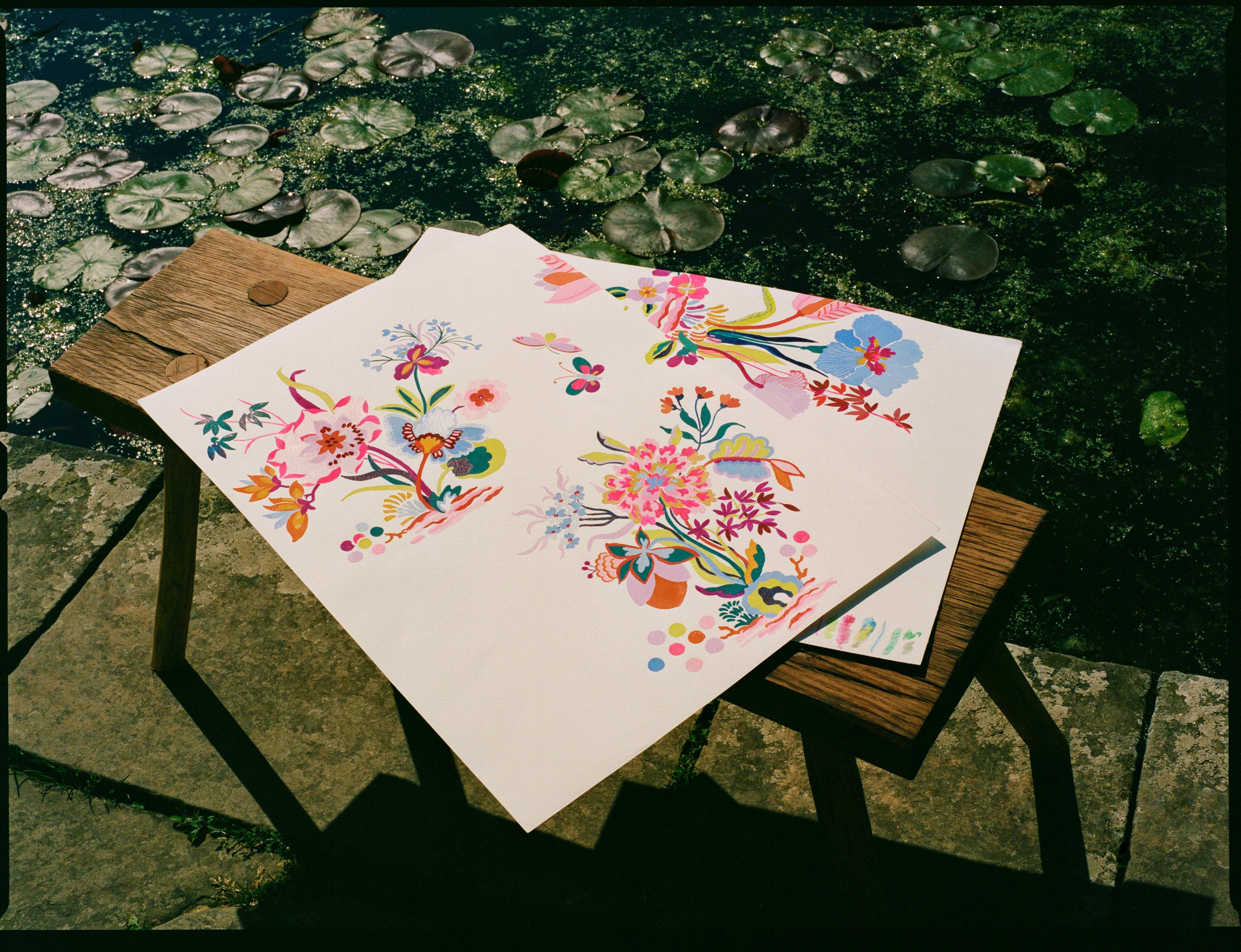 Sketches from the Liberty Fabrics AW26 collection next to a pond in the garden