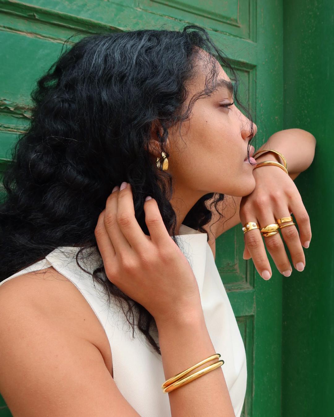 Model wearing Monica Vinader gold jewellery