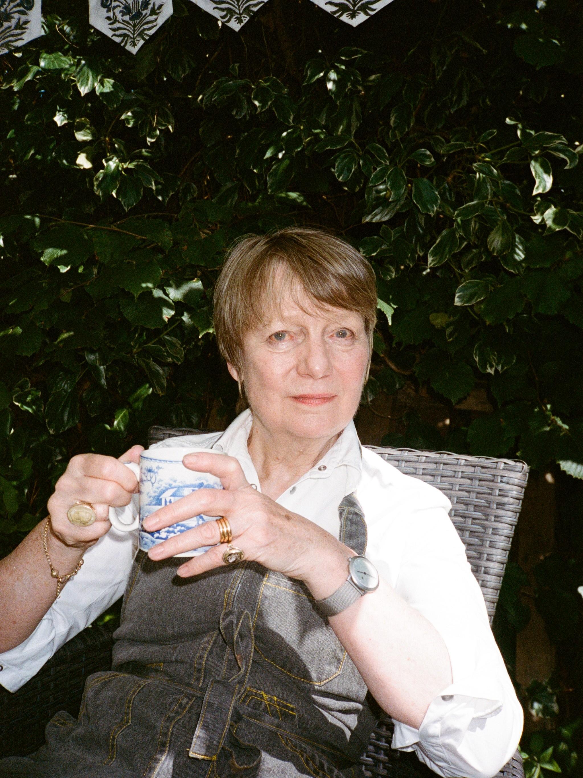 Lizzie Riches sits in her garden with a cup of tea 