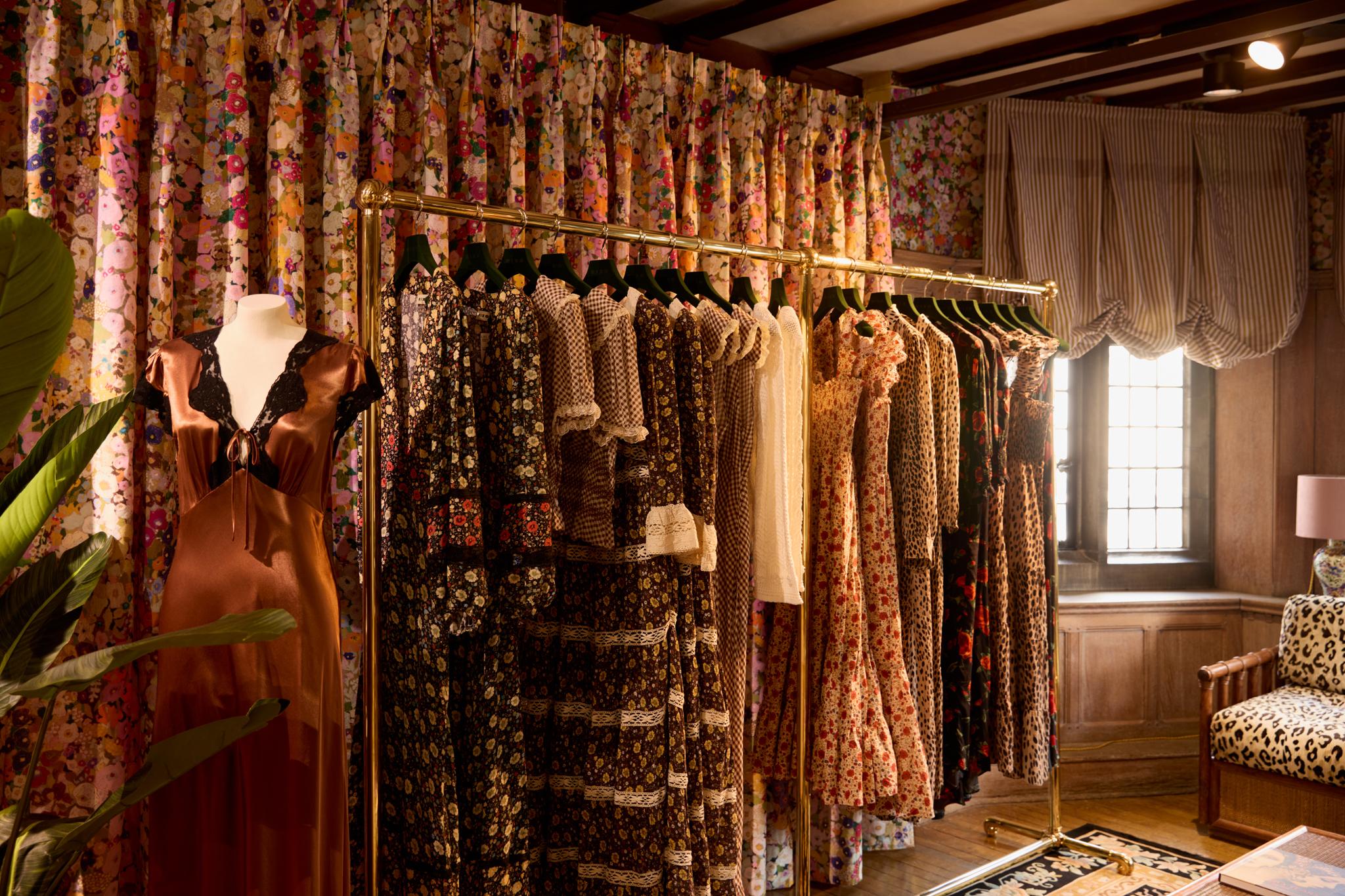 Rixo at Liberty. Racks of elegant vintage inspired dresses against a ditzy floral curtain 