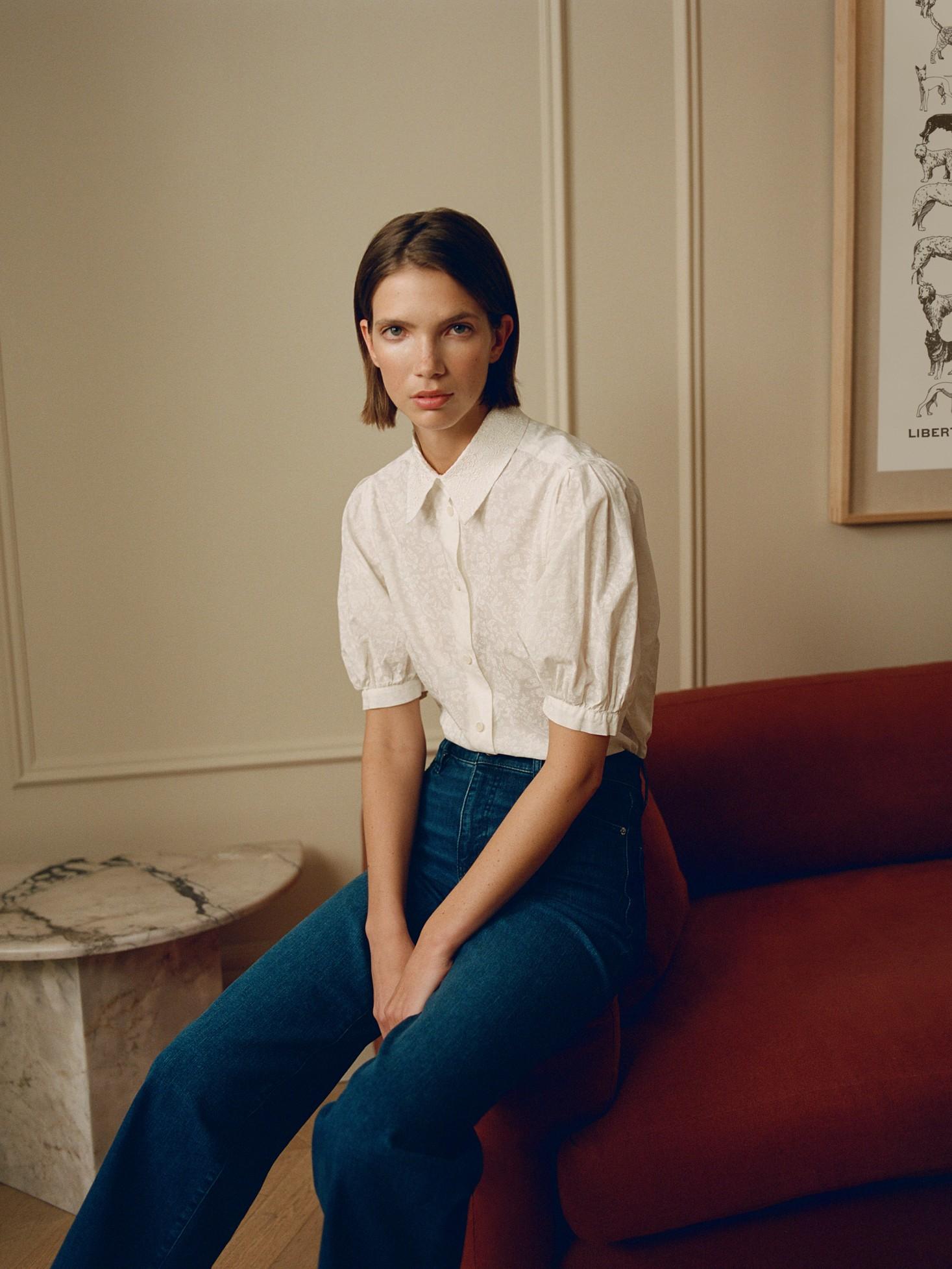 A model wears a grey skirt suit from Ganni