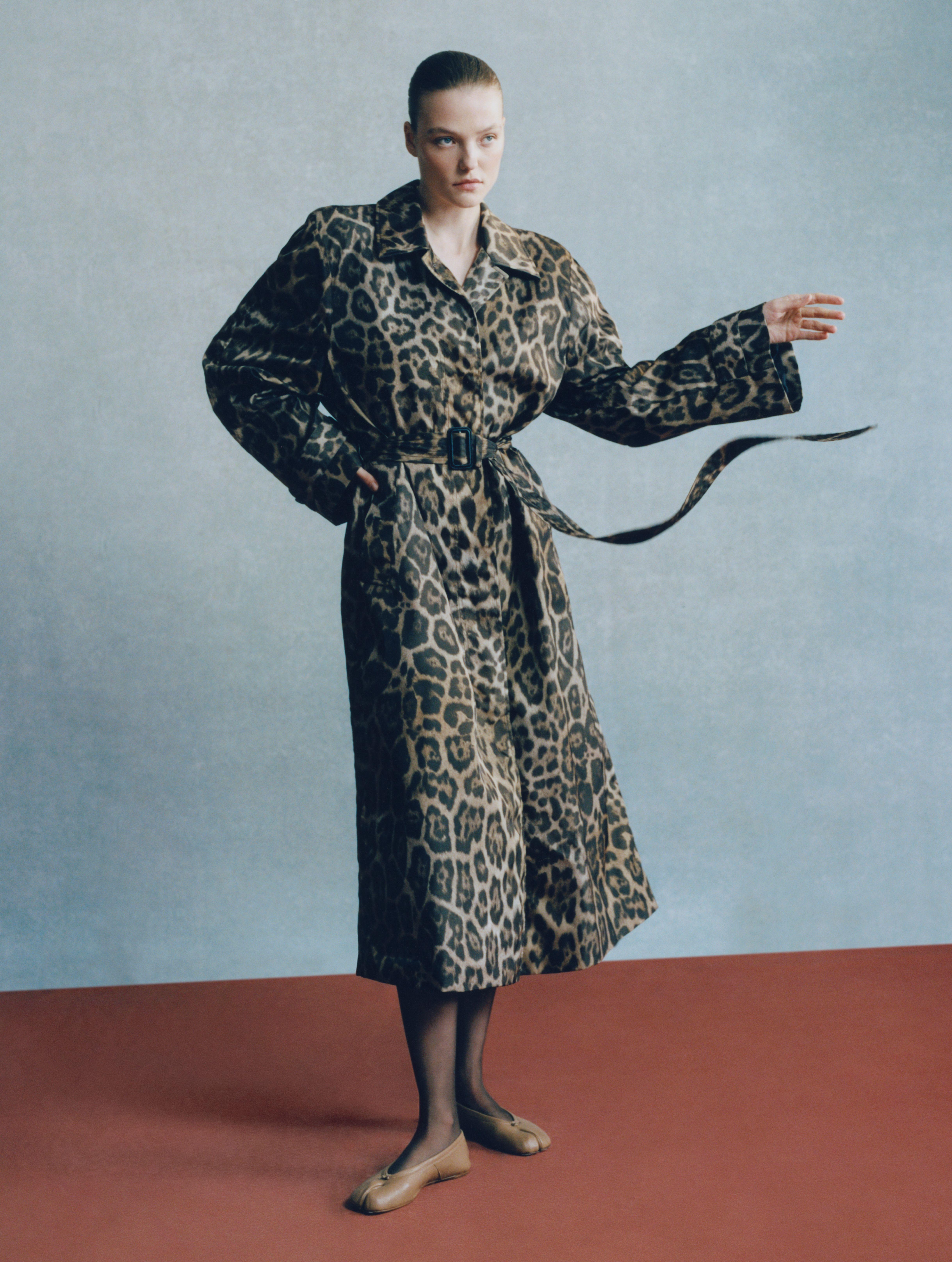 A woman wears a Stella McCartney leopard print trench coat