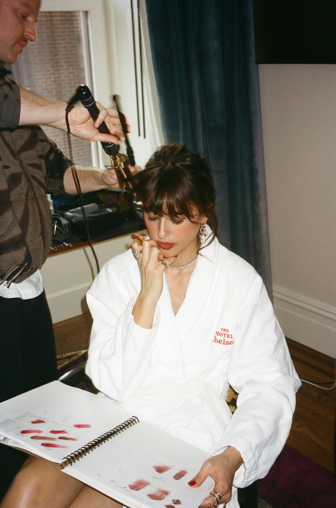 Violette wears a dressing gown and flips through a skecthbook