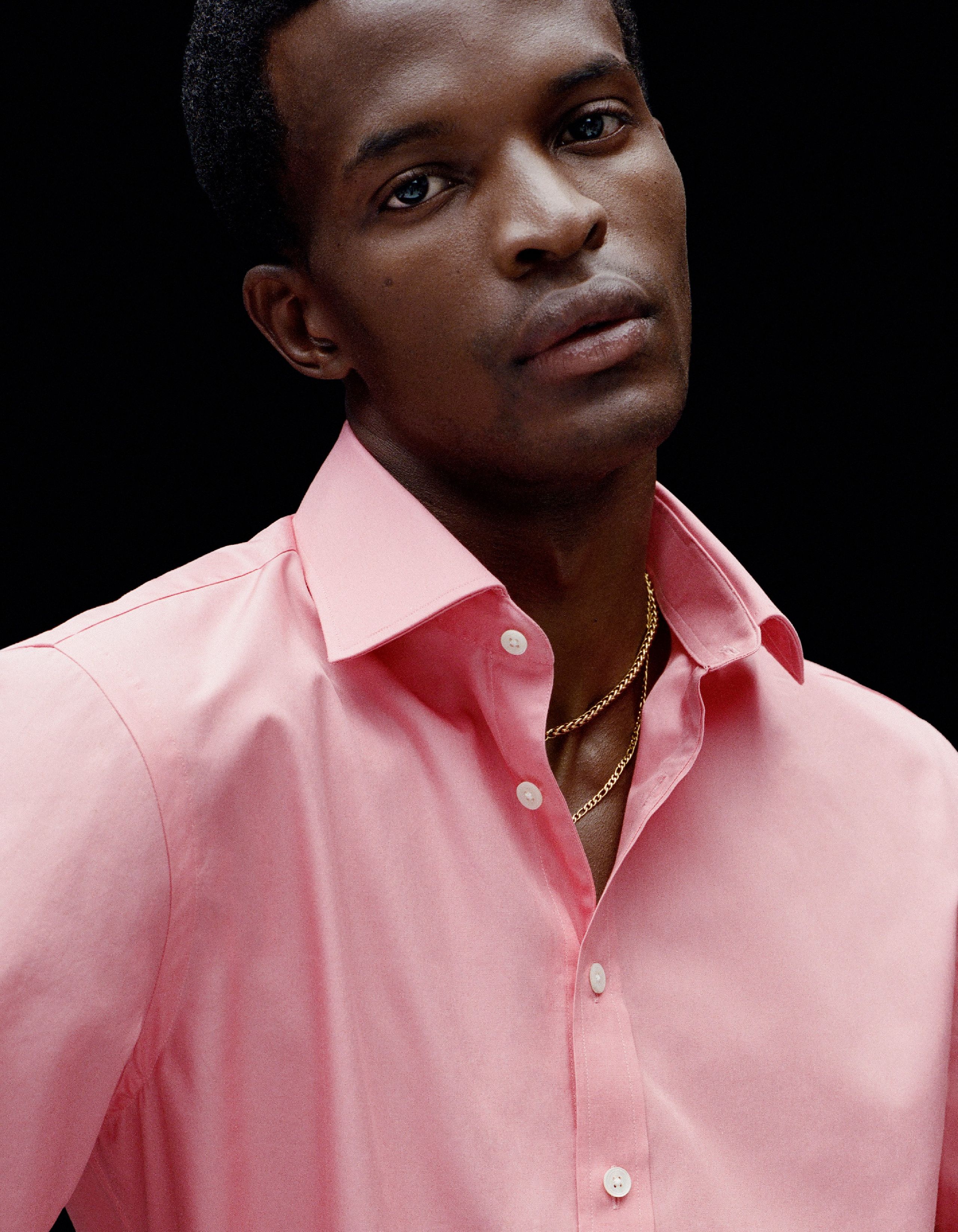 A man wears a pink shirt