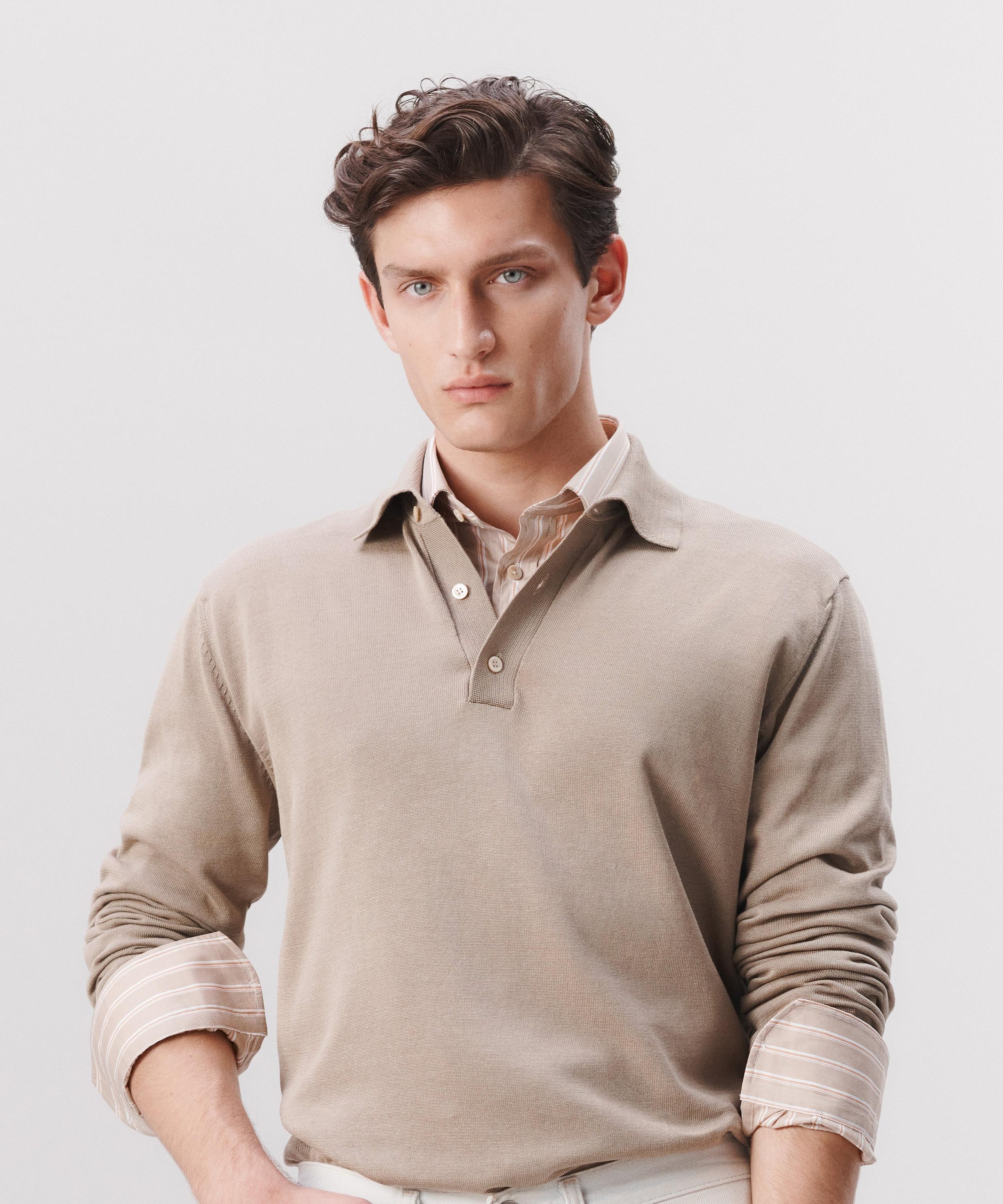 A man wears a shirt layered with a long sleeve polo shirt on top