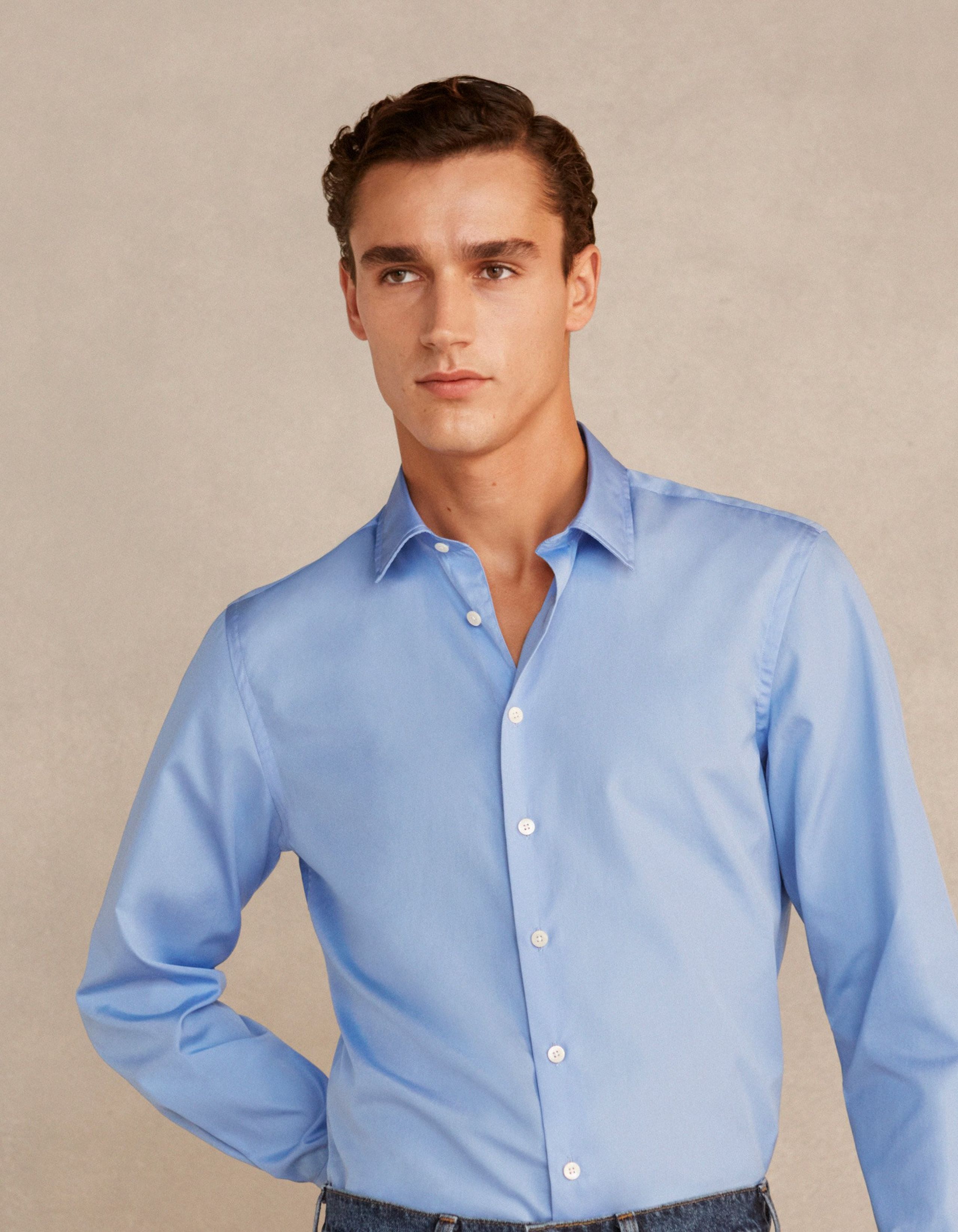 A man wears a blue formal shirt