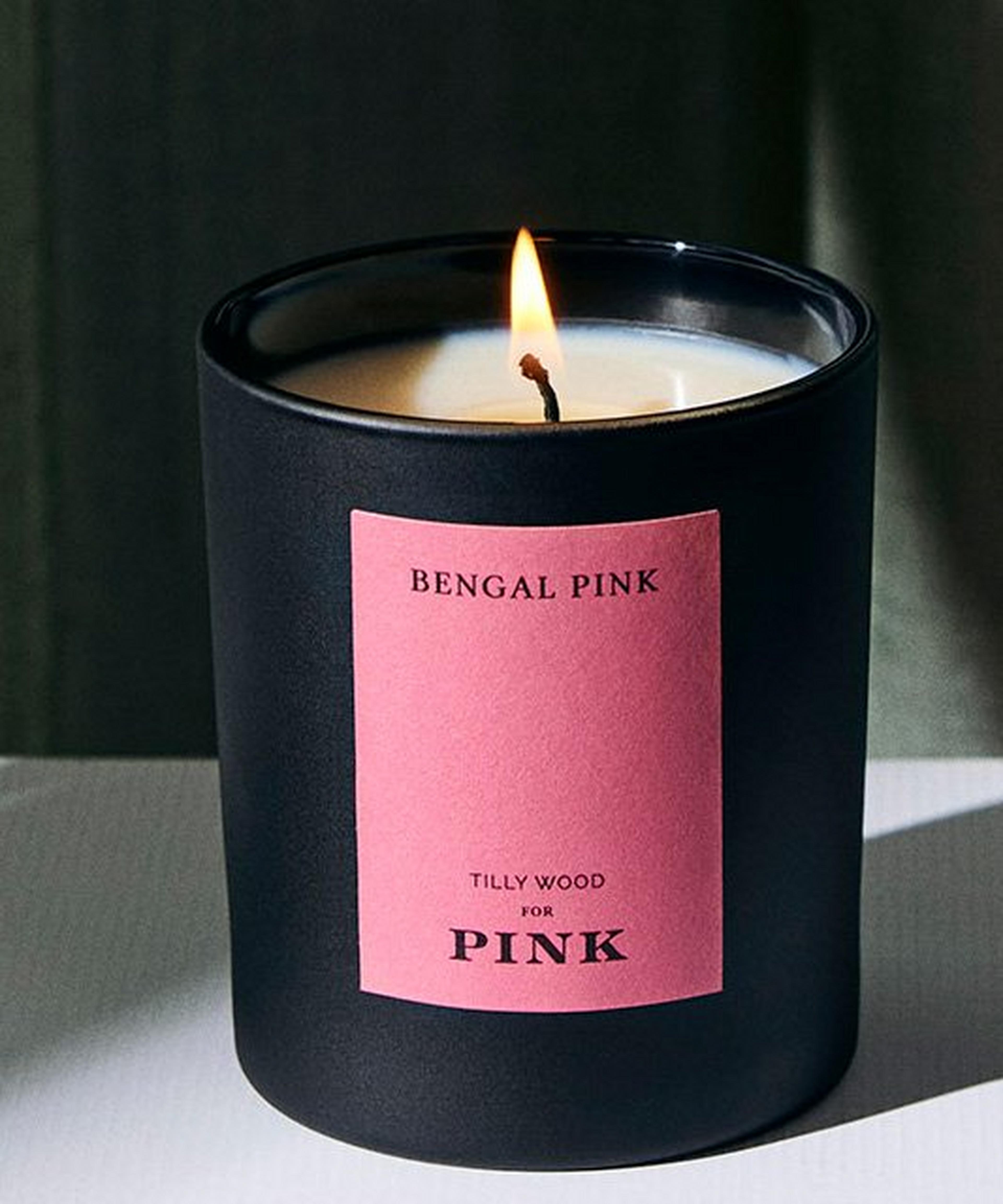A lit candle with a pink label on it