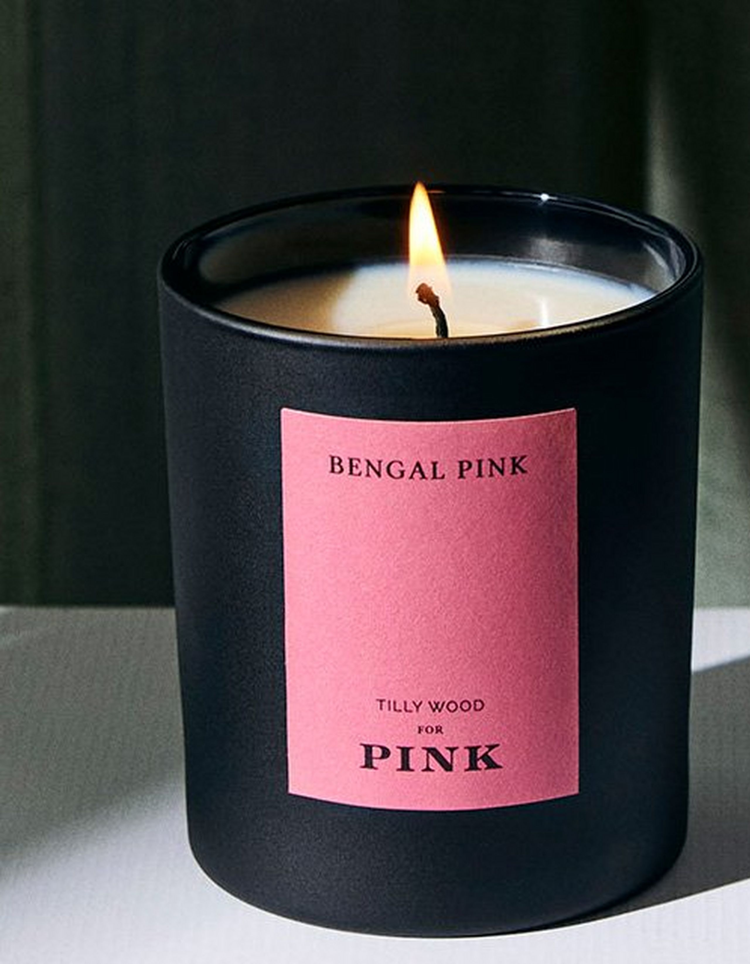 A lit candle with a pink label on it