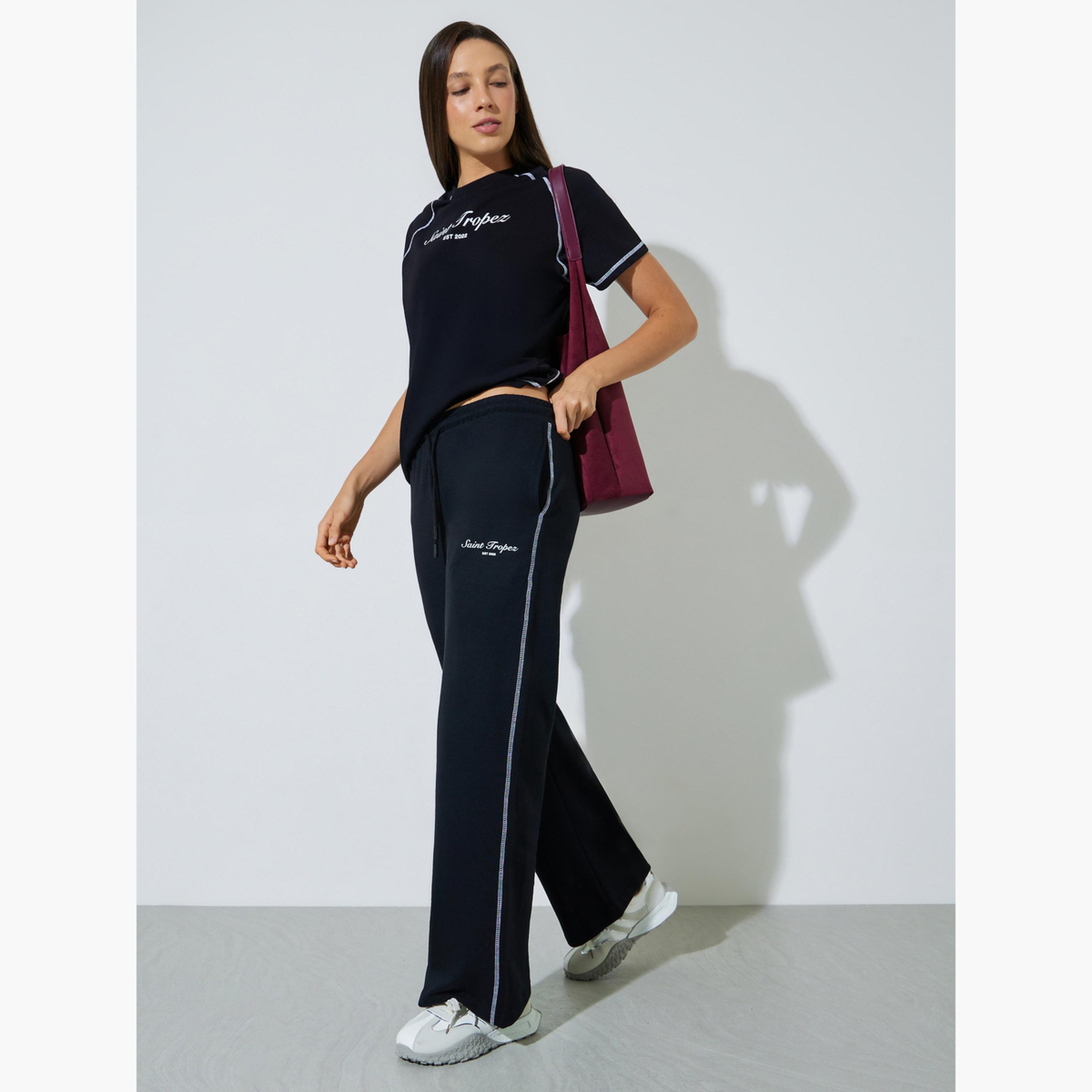 جوغر بأرجل واسعة وطبعة شعار وتطريز متقاطع لون أسود-women-clothing-bottoms-joggers-image-2