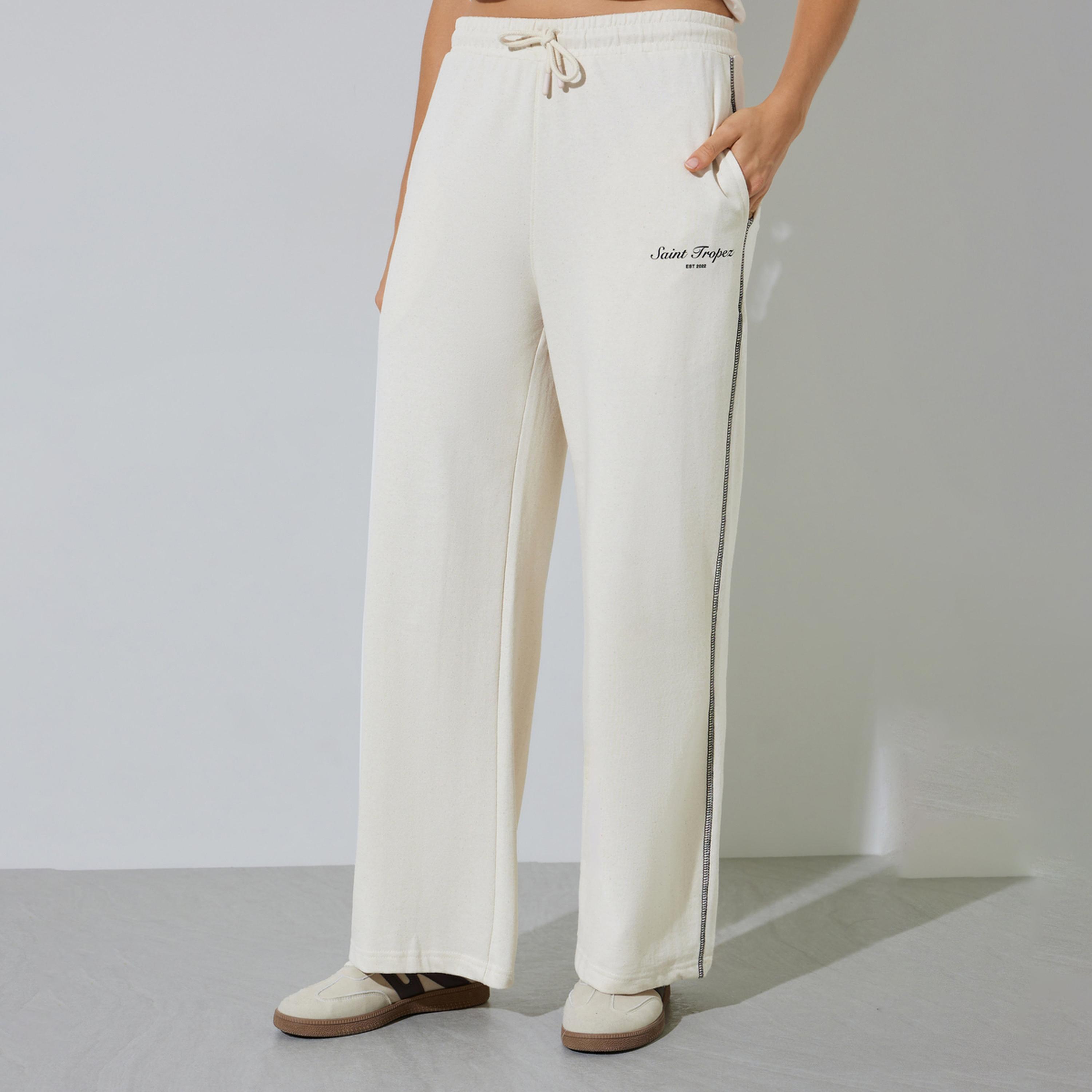 جوغر بأرجل واسعة وطبعة شعار وتطريز متقاطع لون بيج-women-clothing-bottoms-joggers-image-1