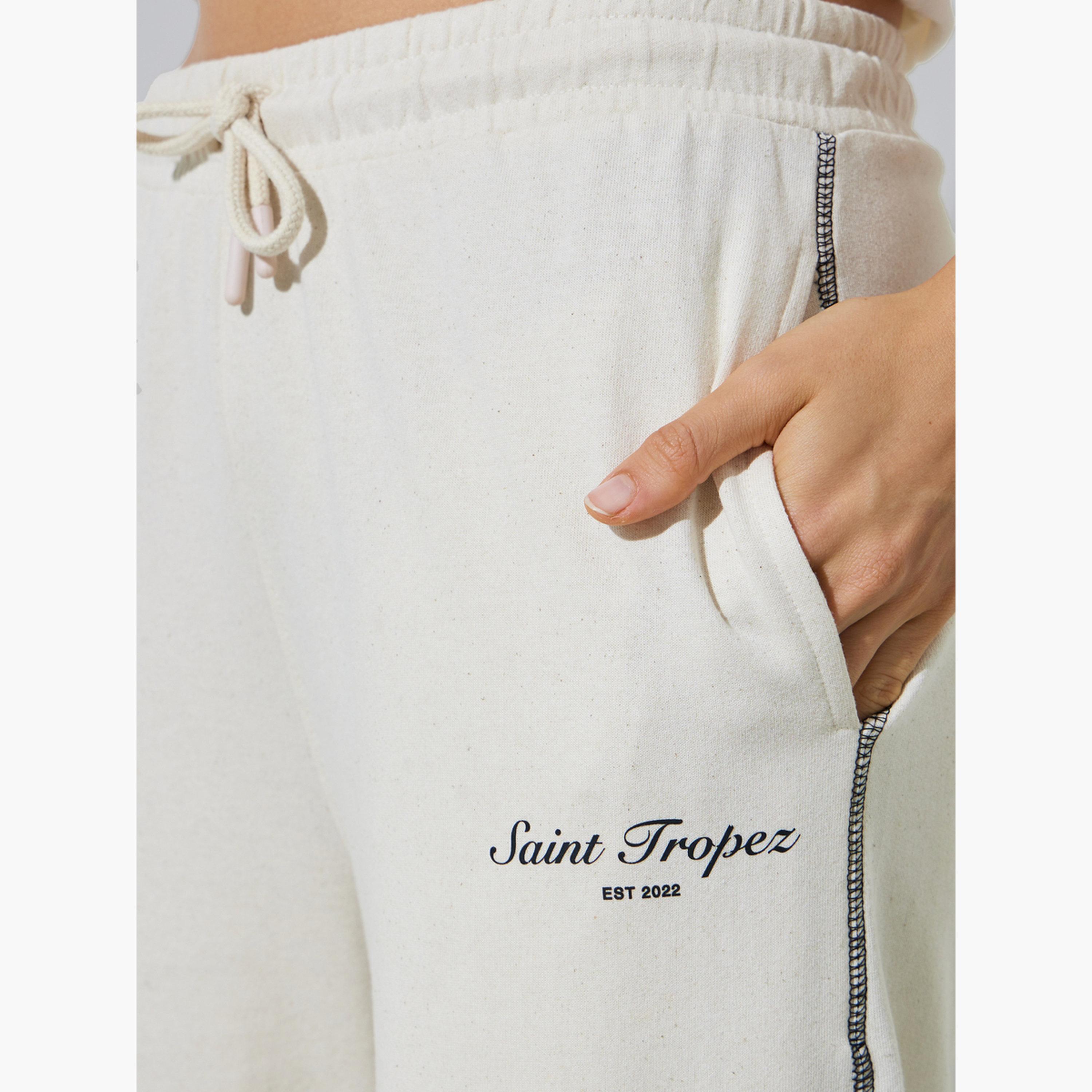 جوغر بأرجل واسعة وطبعة شعار وتطريز متقاطع لون بيج-women-clothing-bottoms-joggers-image-3