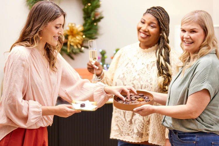 A group of women enjoying a box of Ethel M Chocolates