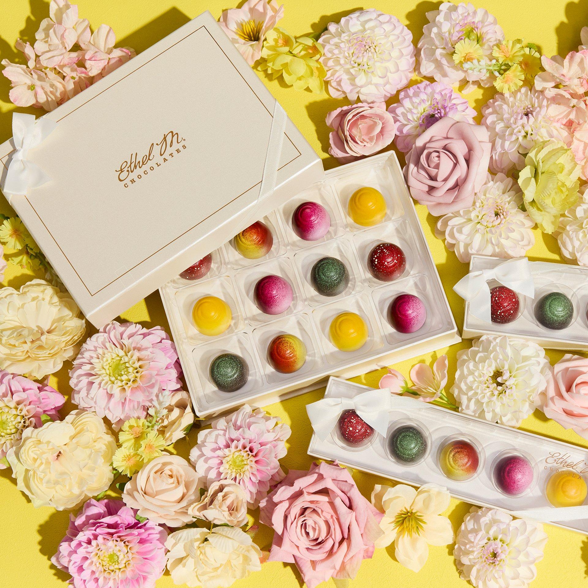 12 piece Custom Chocolate Box filled with Fruit Fusion truffles and 5 piece Fruit Fusion Samplers on yellow background with flowers