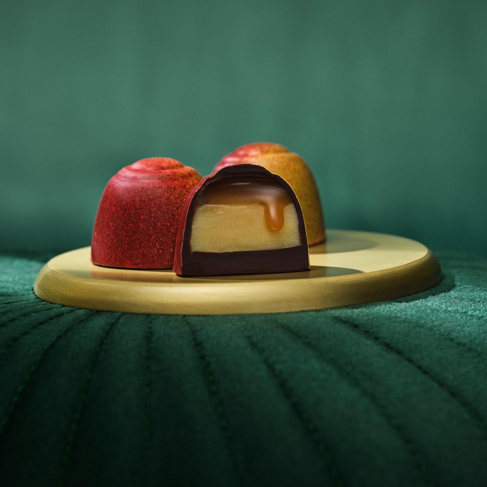 Chocolate gem opened on tray on green background