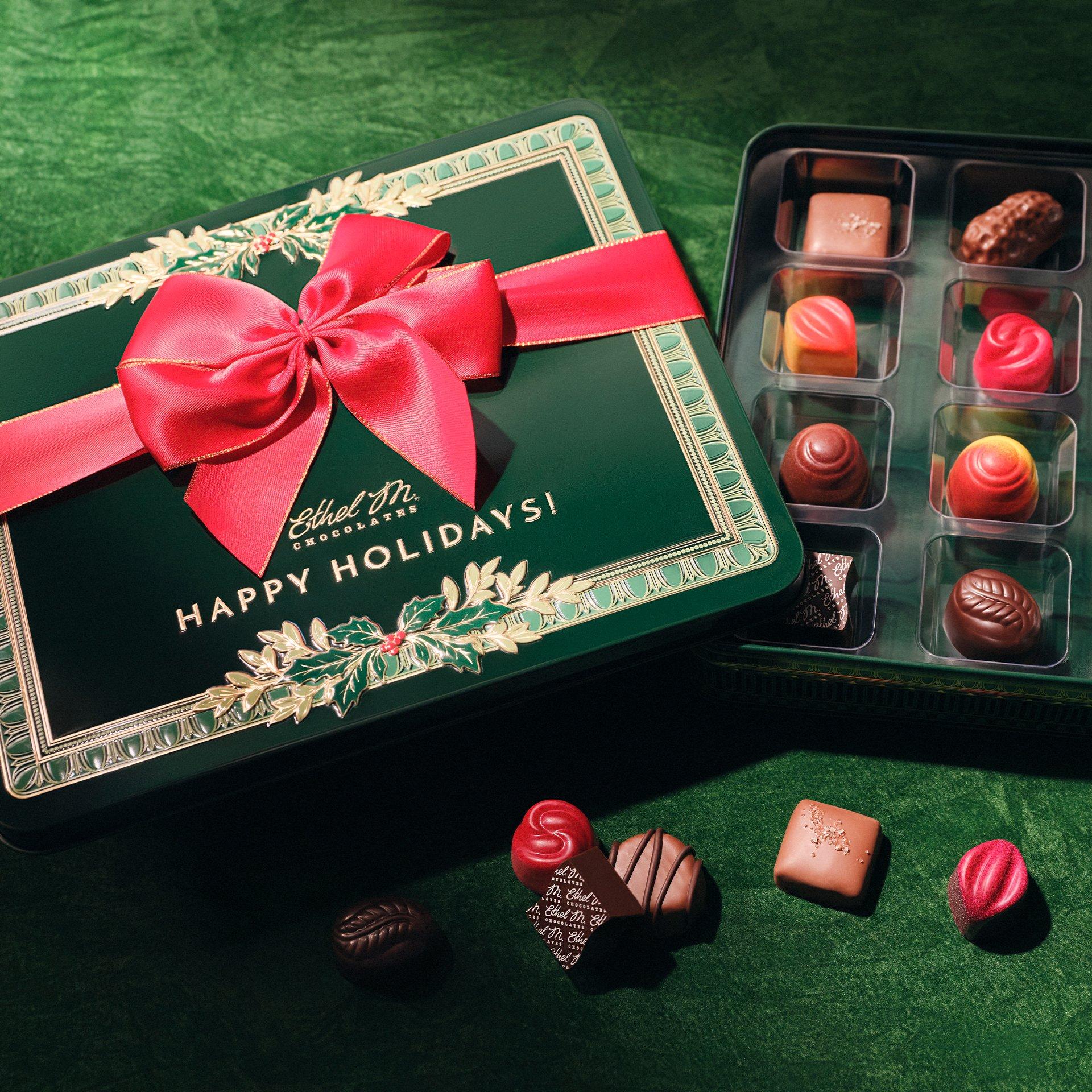 Green Holly Tin with Red Ribbon with Chocolate Gems on Green Background