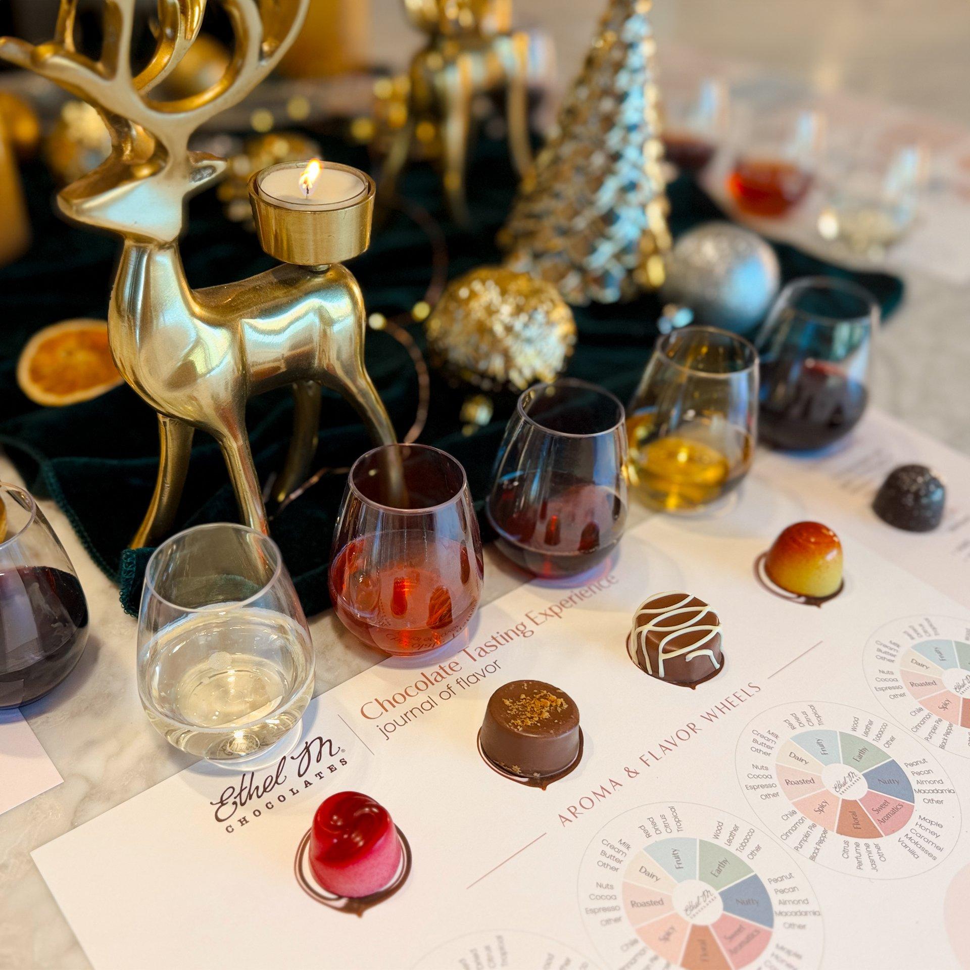 5 chocolate and wine pairings on a tasting mat with Holiday decor at Ethel M Chocolates