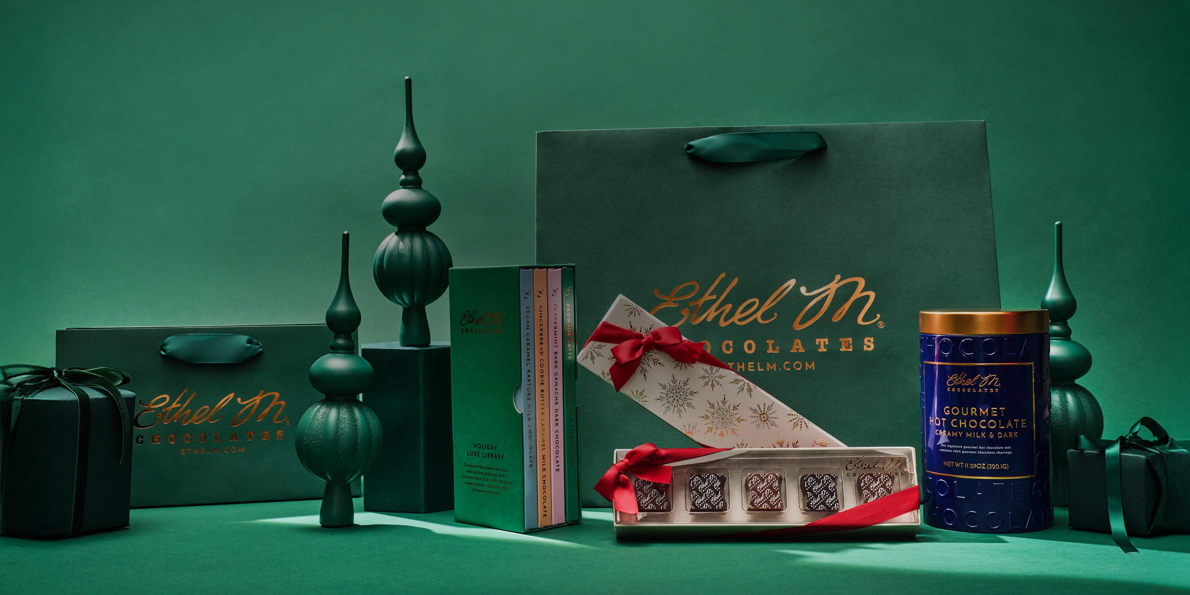 Ethel M Chocolates Holiday Products arranged on a table with Holiday decorations