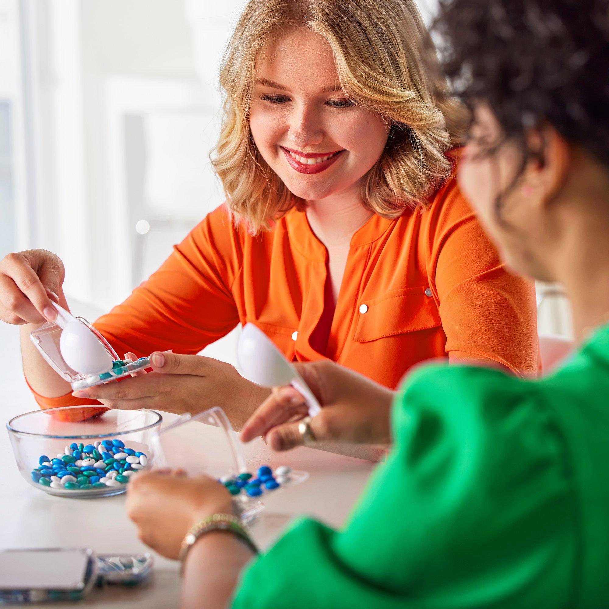 co-workers filling business card holders with personalised m&m's
