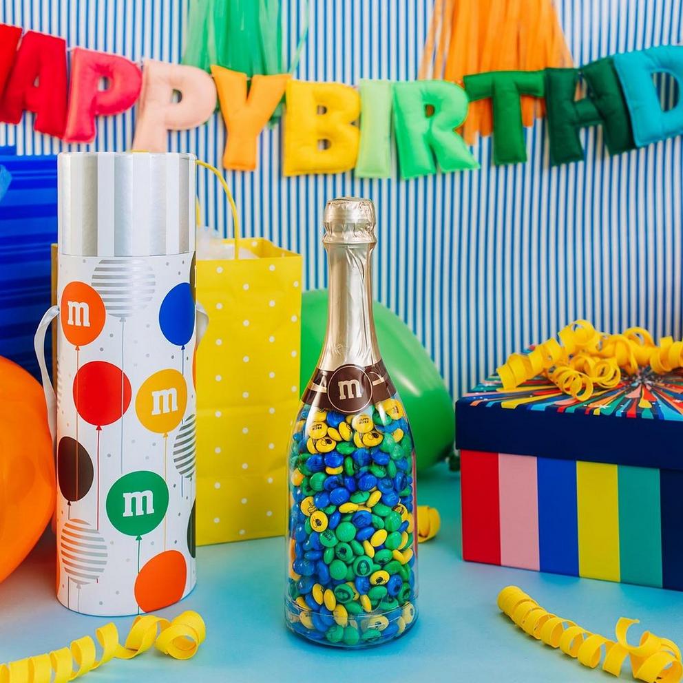birthday gift bottle on table with presents and decorations