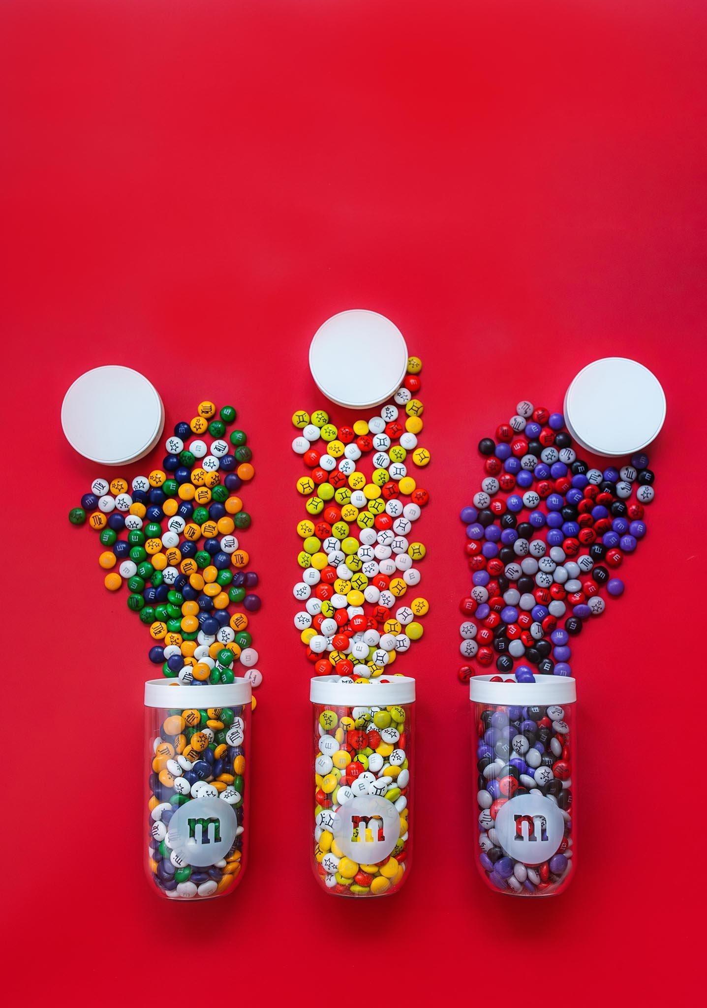 three jars of personalized M&M'S being poured out onto table