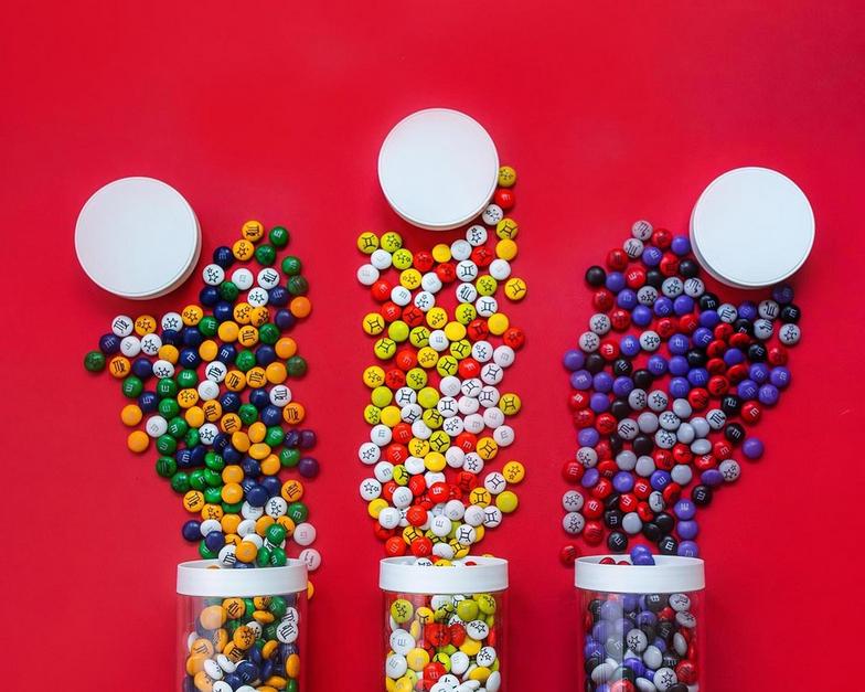 three jars of personalized M&M'S being poured out onto table